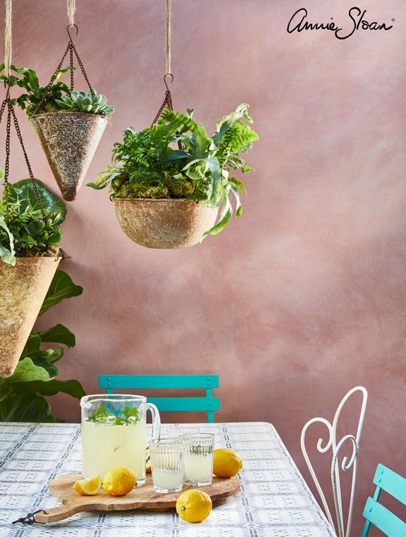 three hanging planters filled with lemons and green plants on a dining room table