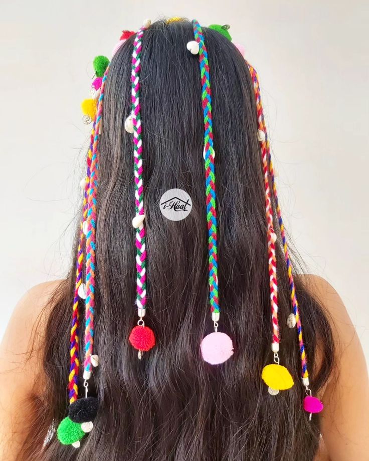 the back of a woman's head with long hair and multicolored beads