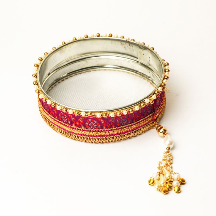 A specially curated Chalni for the auspicious celebration of Karwa Chauth, this Chalni is handmade with pure rawsilk fabric with golden & pearl colored beads that look absolutely elegant. Standard Chalni - 6.5 inches in diameter Gift this Pooja thali along with chalni for your wife who would be keeping a fast for you on the festive occasion of Karwa Chauth Silk Thread Jewelry With Gota Work For Gift, Silk Thread Jewelry For Festivals, Festival Silk Thread Jewelry, Wedding Dupatta In Brocade With Tilla Detail, Elegant Embroidered Jewelry For Festive Occasions, Elegant Traditional Wear With Gota Work For Ceremonies, Elegant Embroidered Festive Jewelry, Festive Ceremonial Dupatta With Gota Work, Ceremonial Festive Dupatta With Gota Work