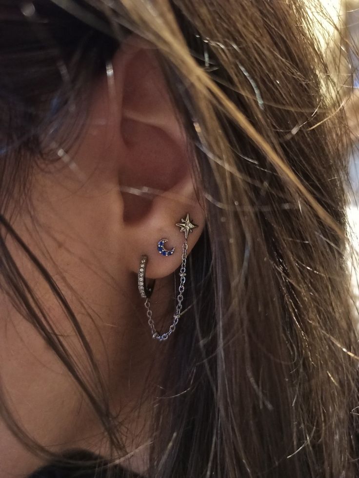 Triple lobe piercing, with moon and stars earrings. The star is connected with the first lobe piercing by a metal string with little stars incastoneted. 1st 2nd And 3rd Piercings, How To Style Triple Lobe Piercing, 3 Lobe Piercings Ideas Silver, Triple Lobe Piercing Ideas Silver, Three Lobe Piercings And Cartilage, Triple Lobe Piercing Ideas, 3rd Lobe Piercing, 3 Lobe Piercings Ideas, Triple Piercing Earrings