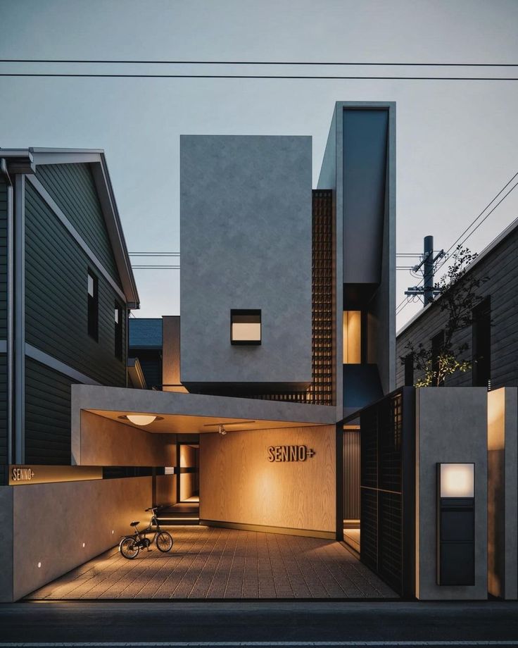 a bike is parked in front of the entrance to a modern house at night time