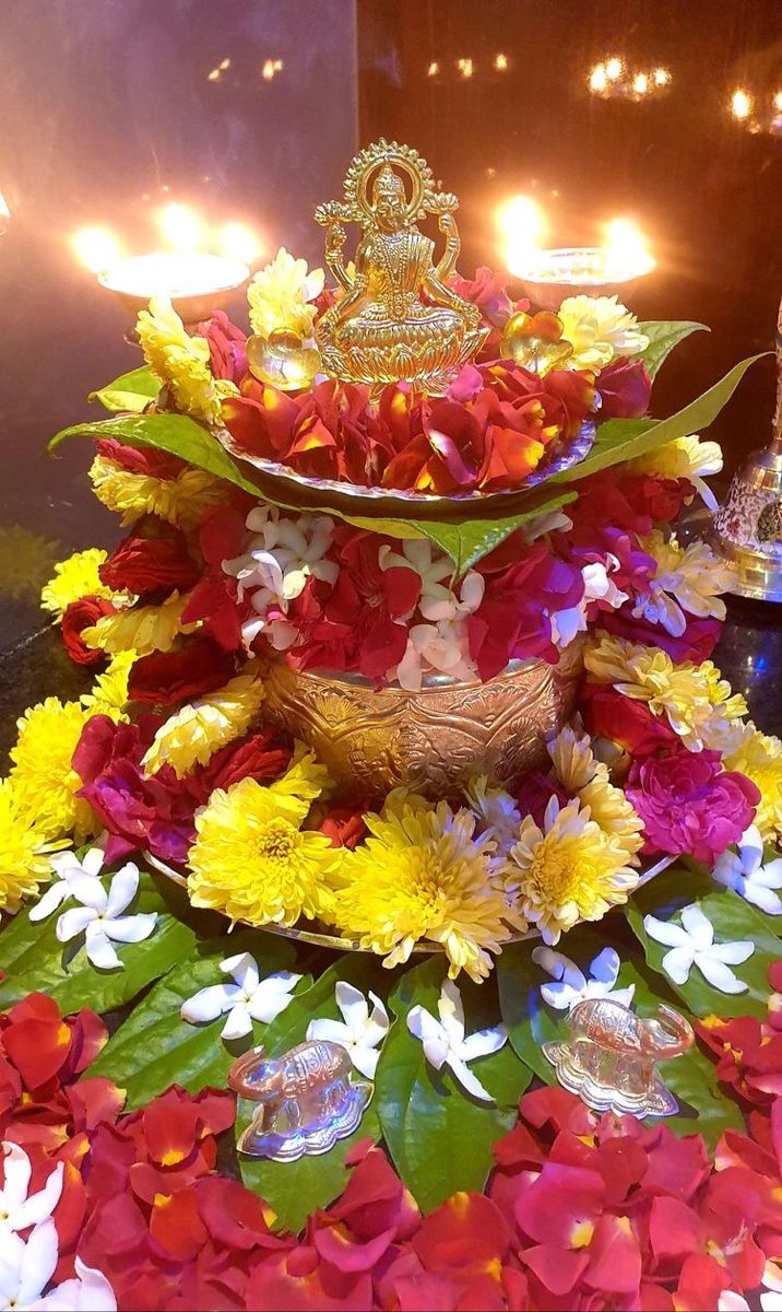 there is a decorative arrangement with flowers and candles on the table in front of it