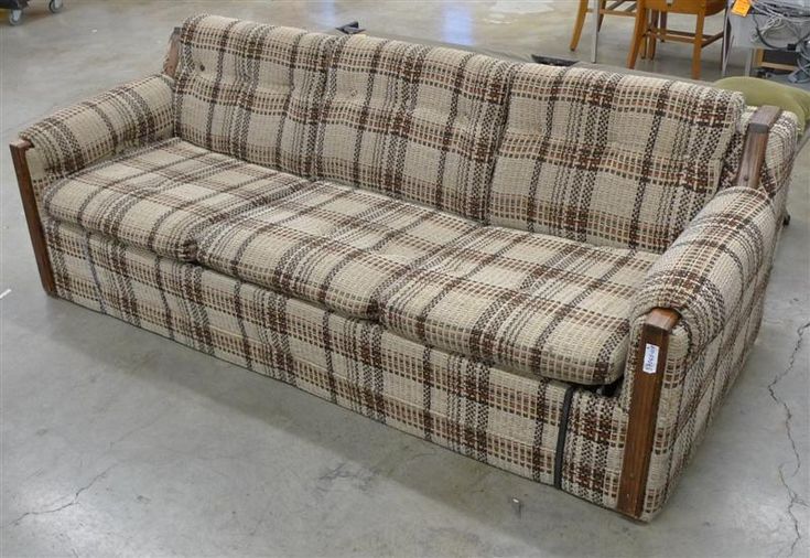 a couch that is sitting on the floor in a room with chairs and other furniture