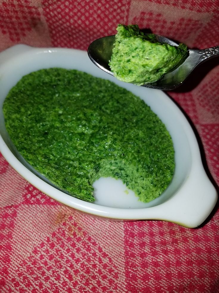 a spoon with some green food in it