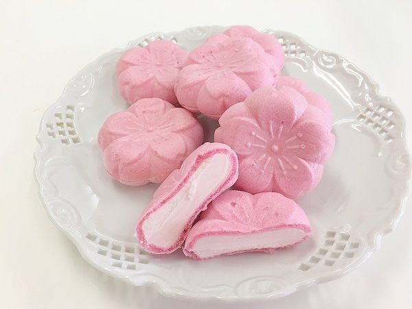 some pink cookies are on a white plate