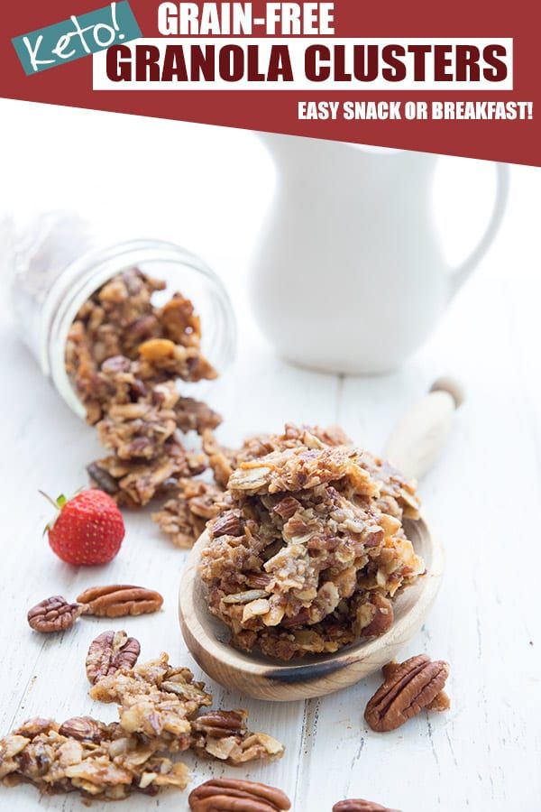 granola clusters in a wooden spoon on top of a white table with strawberries