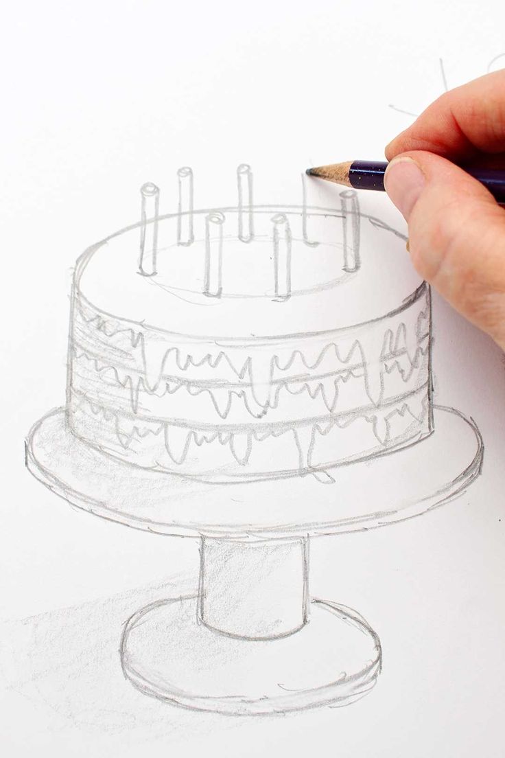 a drawing of a cake with candles on it and a person's hand holding a pencil