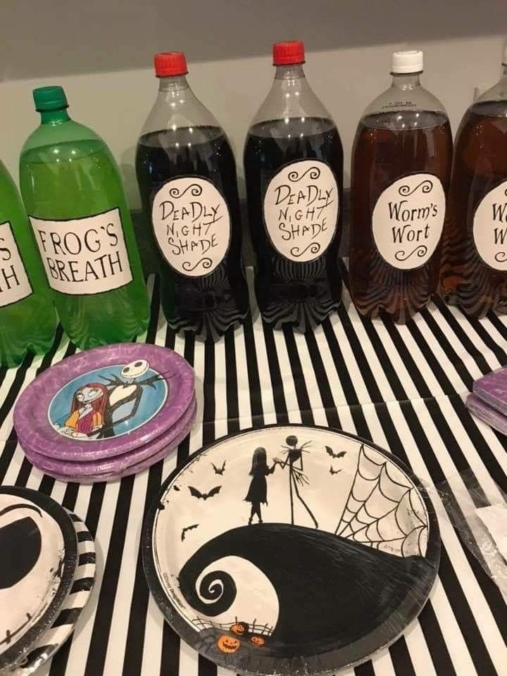 there are many halloween themed plates and drinks on the striped tablecloth with black and white stripes