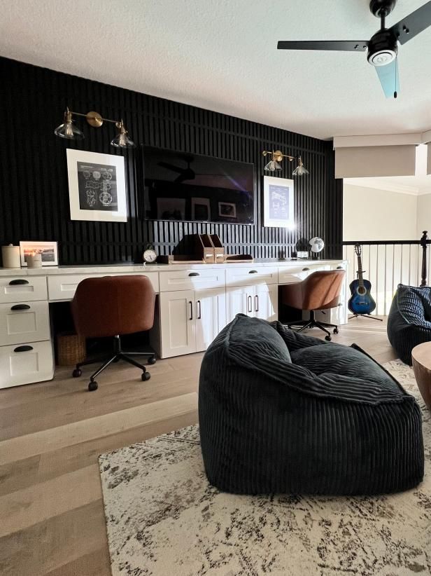 a living room filled with lots of furniture and black wall coverings on the walls