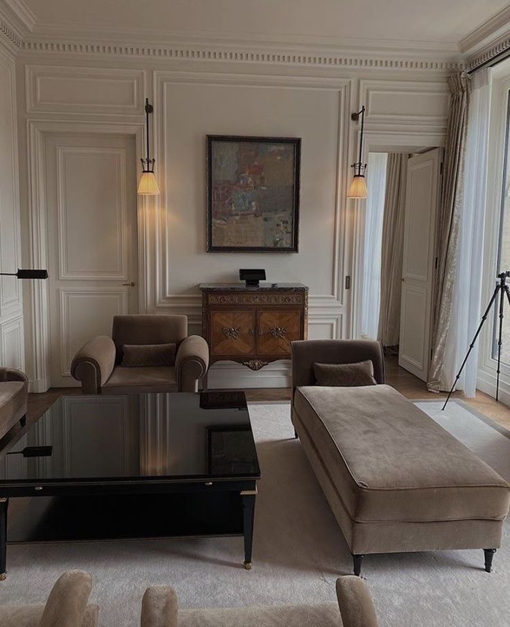 a living room with couches, chairs and a table in front of a window