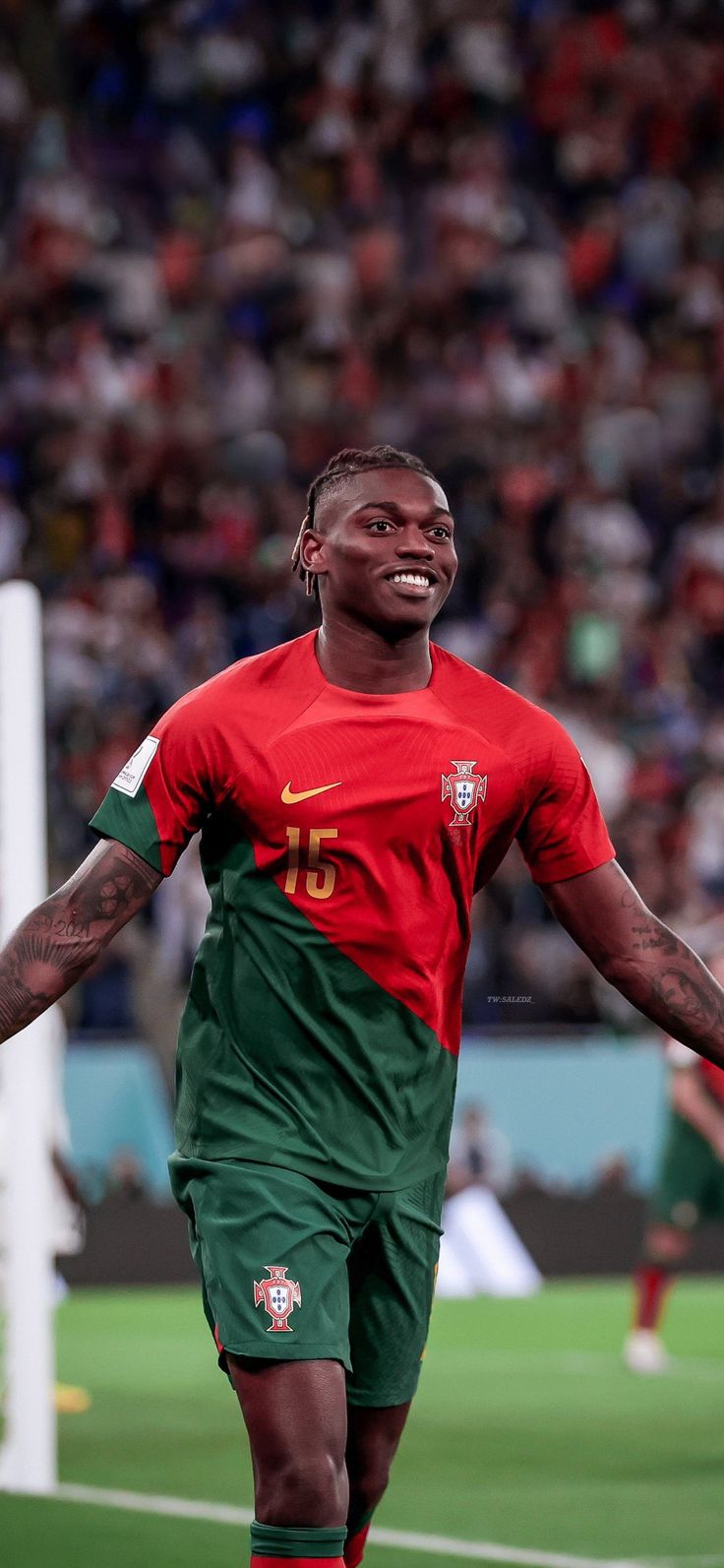 a male soccer player in a red and green uniform