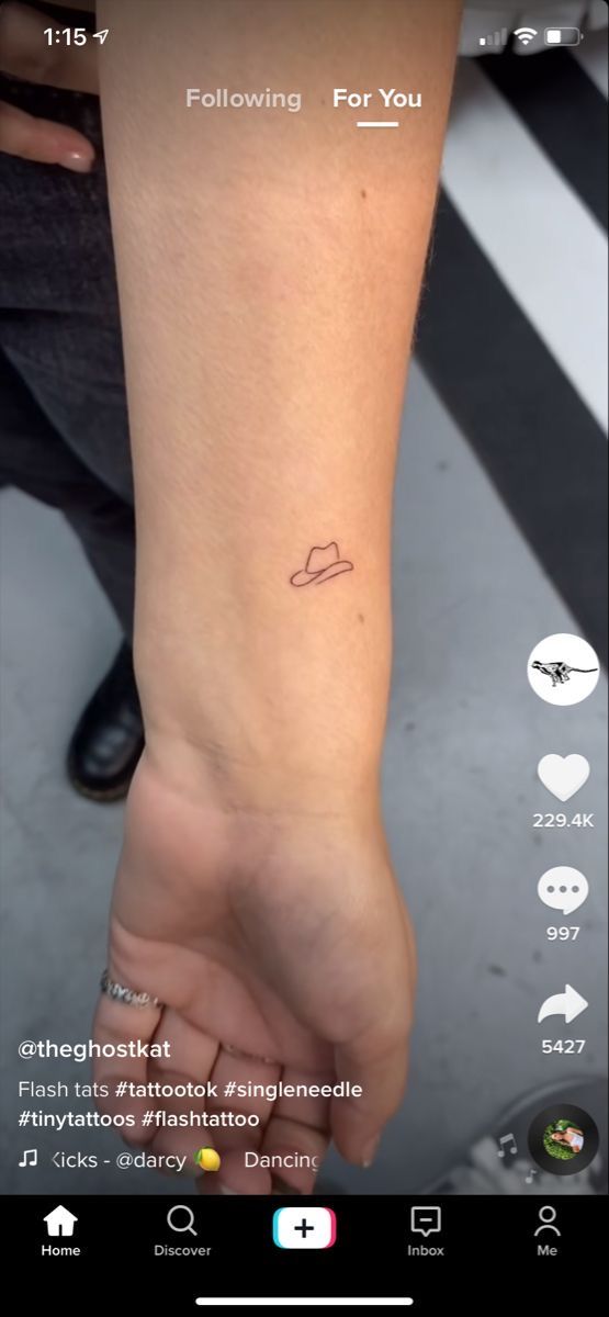 someone is holding their hand up to show the tattoo on her wrist, which reads following for you