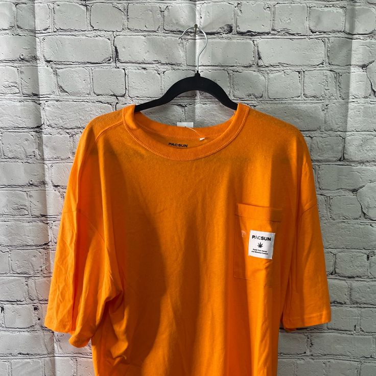 Brand New Pac Sun Graphic Pocket T-Shirt Fits Big Perfect Condition Orange Top With Letter Print And Relaxed Fit, Casual Orange Tops With Letter Print, Casual Orange Tops For Streetwear, Casual Orange Shirt With Letter Print, Basic Orange Tops For Streetwear, Casual Orange Crew Neck Top, Basic Orange T-shirt For Spring, Relaxed Fit Orange Top With Letter Print, Casual Tan Short Sleeve Tops