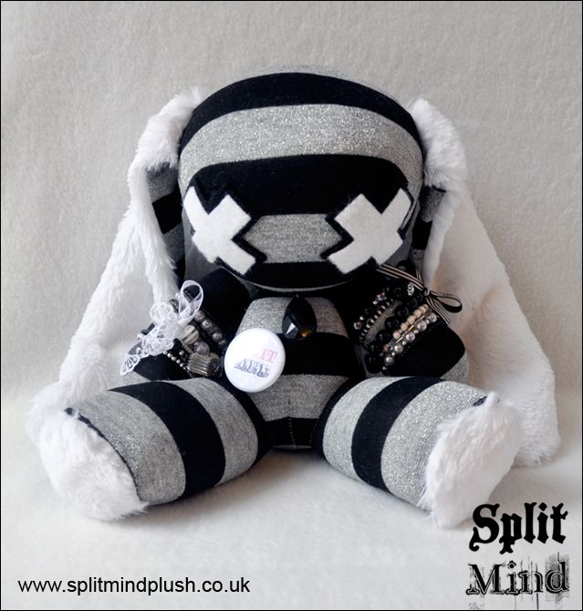 a black and white striped stuffed animal sitting on top of a bed