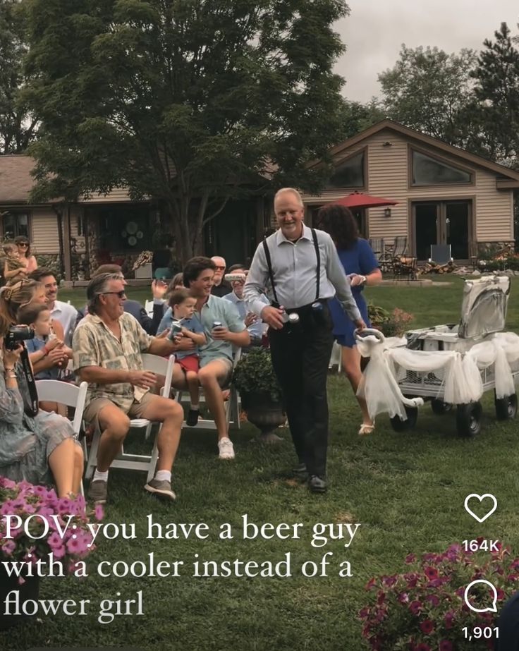 a man walking down a grass covered field next to a group of people sitting in lawn chairs