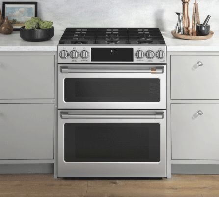 a kitchen with two ovens and white cabinets