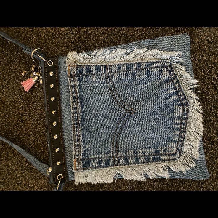 a pair of jeans that have been ripped and are laying on the ground with a chain attached to it