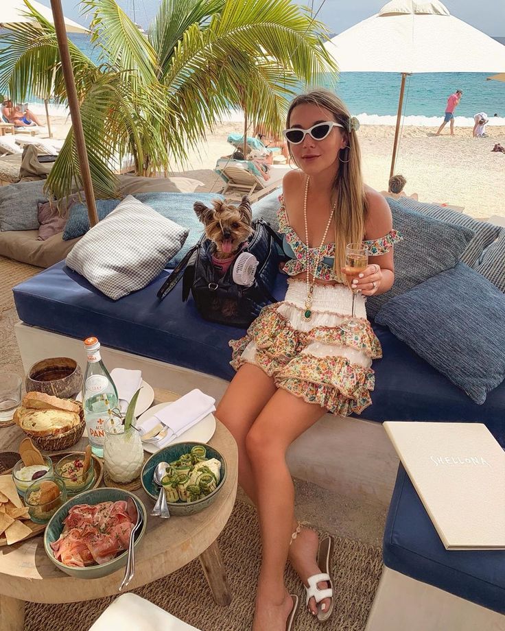 a woman sitting on top of a blue couch next to a table filled with food