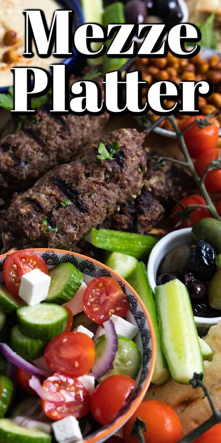 a platter filled with meat, vegetables and pita bread on top of a table