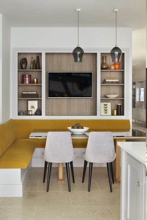 a room with two chairs and a table in it that has a television on the wall