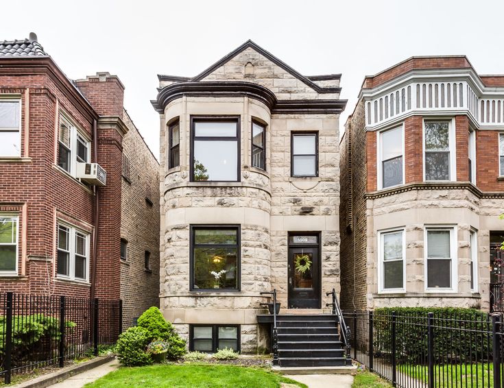 two story brick house with black iron fence