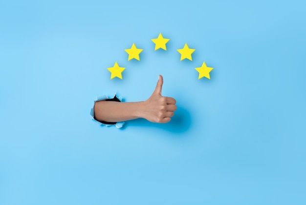 a thumbs up sign with five yellow stars coming out of it on a blue background