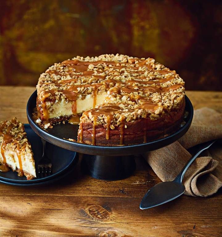 a cheesecake with caramel drizzled on top and two slices cut out