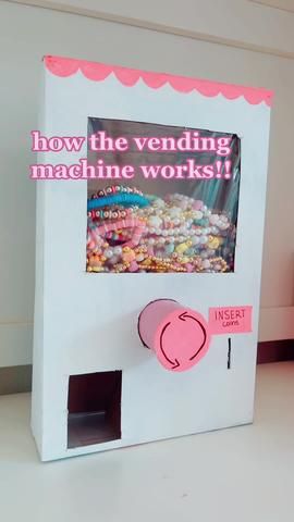 a machine that is sitting on top of a table next to a box with candy in it