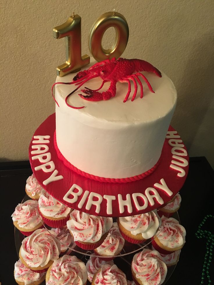 a red and white birthday cake with cupcakes