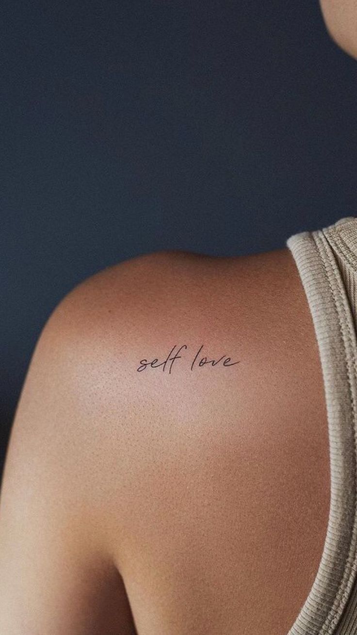 the back of a woman's shoulder with words on it that say self love