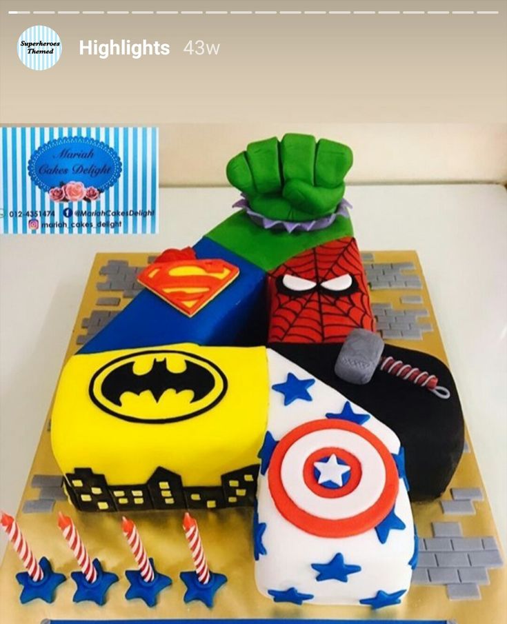 a birthday cake is decorated with superheros and captain america symbols, including an ironman's helmet