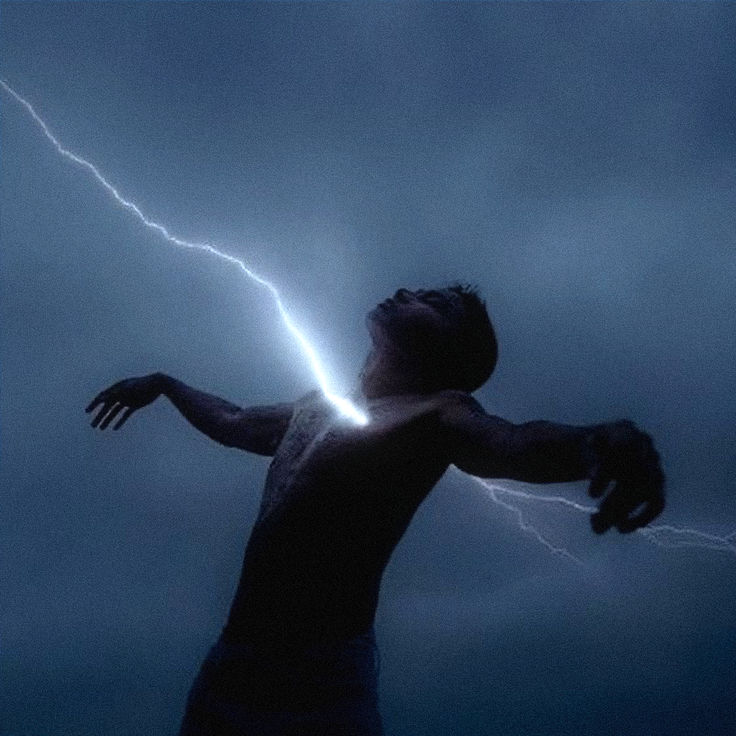 a man standing in front of a lightning storm with his arms out to the side