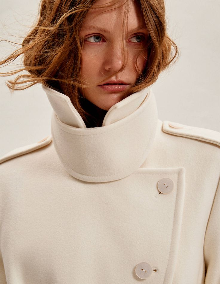 Coat with classical collar and long sleeves designed using fabric from Italian textile innovators. Belted coat is made using a wool and cashmere which are then repurposed into high-quality yarns with a soft handfeel.​ The milk hue, wrap-over design and back vent add sophistication.A classic spread collar with a detachable throat latch. It has adjustable cuffs and a belt for a personalised fit. Tailored finishes include a subtle back vent and front welt pockets.80% wool 20% cashmere 100% viscose Classic White Wool Coat, White Classic Wool Coat, Cream Wool Outerwear With Lapel Collar, White Wool Long Coat, White Wool Coat For Winter, Beige Wool Shawl Collar Outerwear, Chic White Wool Outerwear, White Wool Coat With Lapel Collar For Fall, Cream Wool Coat For Fall