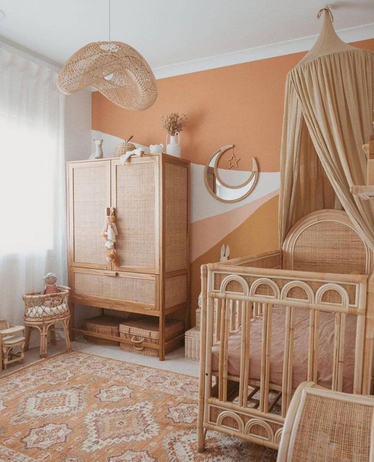 a baby's room with an orange and white striped wall, wicker crib, beige bedding, and wooden furniture