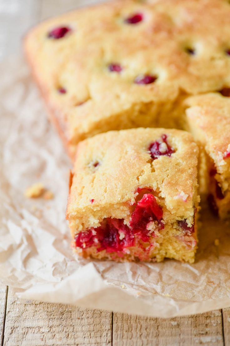 the cake is cut into pieces and ready to be eaten with cranberry toppings