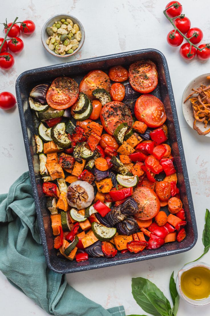 a pan filled with lots of different types of vegetables on top of a white table