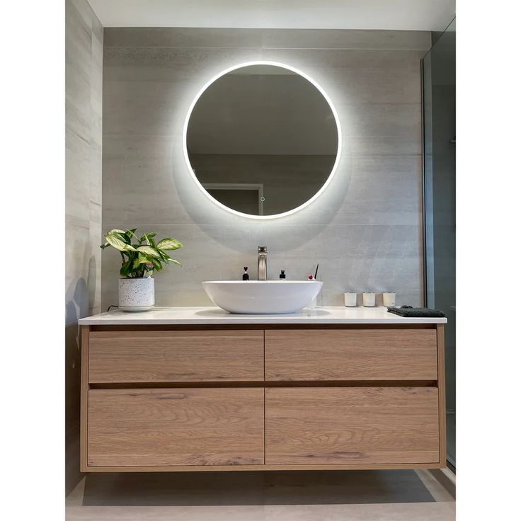 a bathroom with a round mirror above the sink