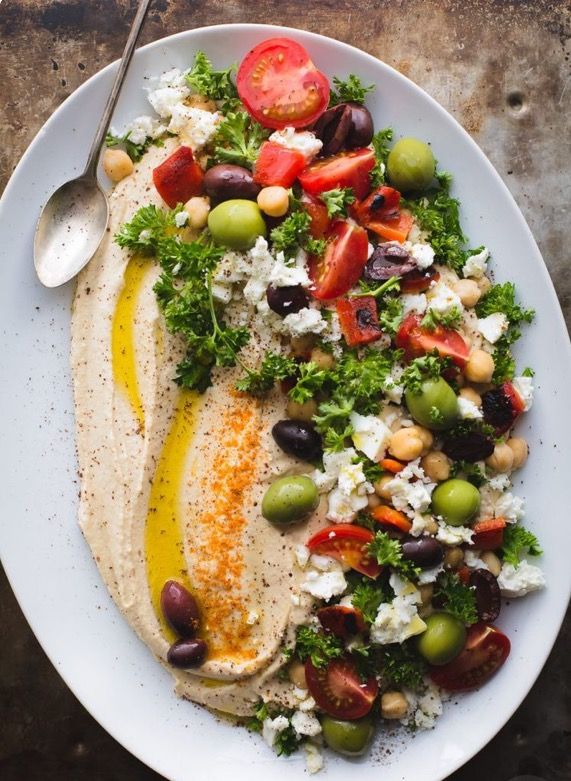 a white plate topped with salad and pita bread