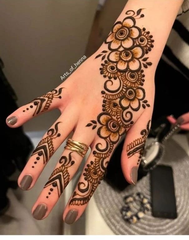 a woman's hand with henna tattoos on it