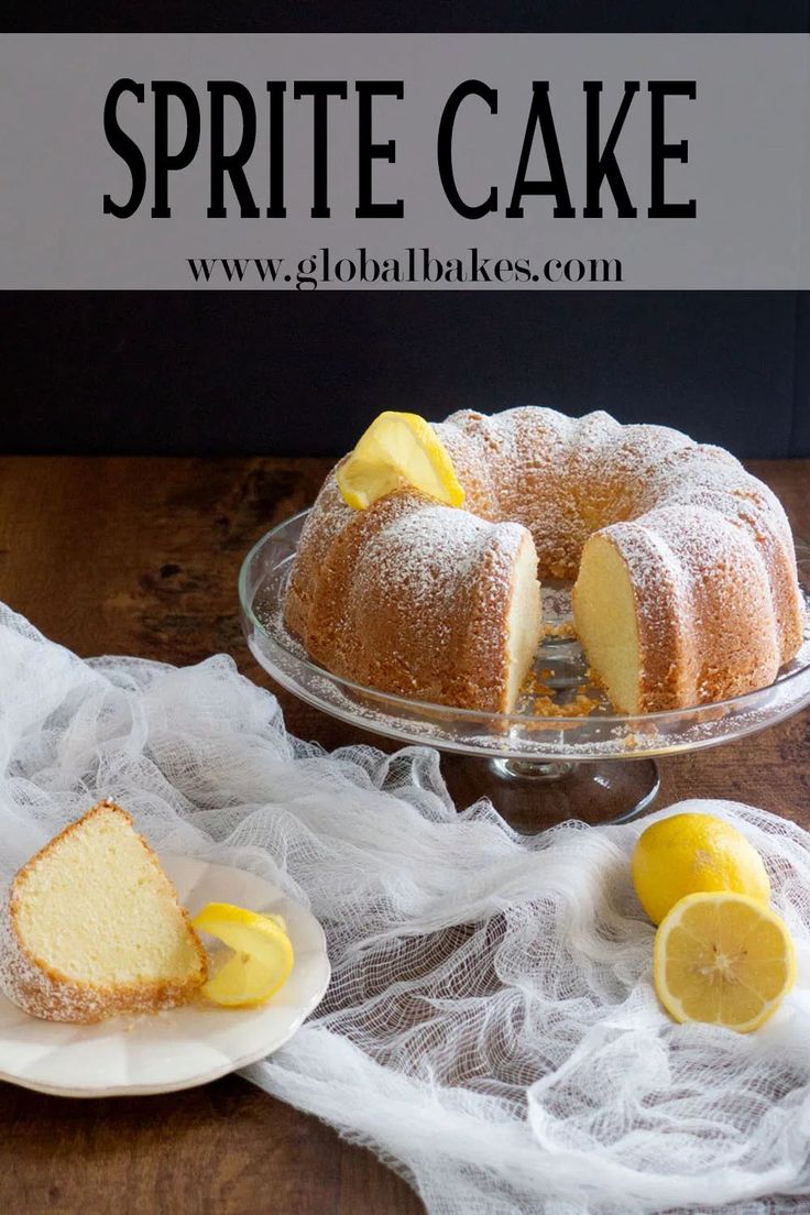 a cake on a plate with lemons and powdered sugar next to the cake