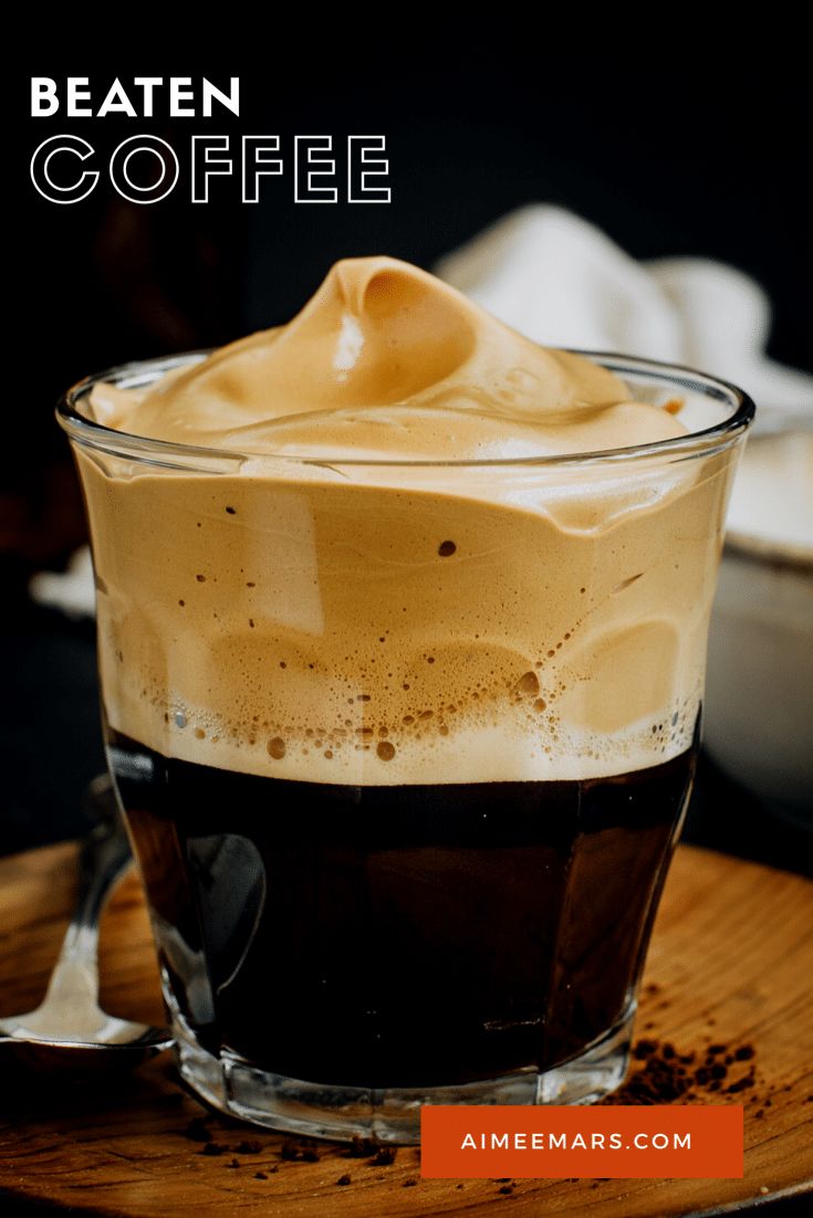 a glass cup filled with coffee on top of a wooden table