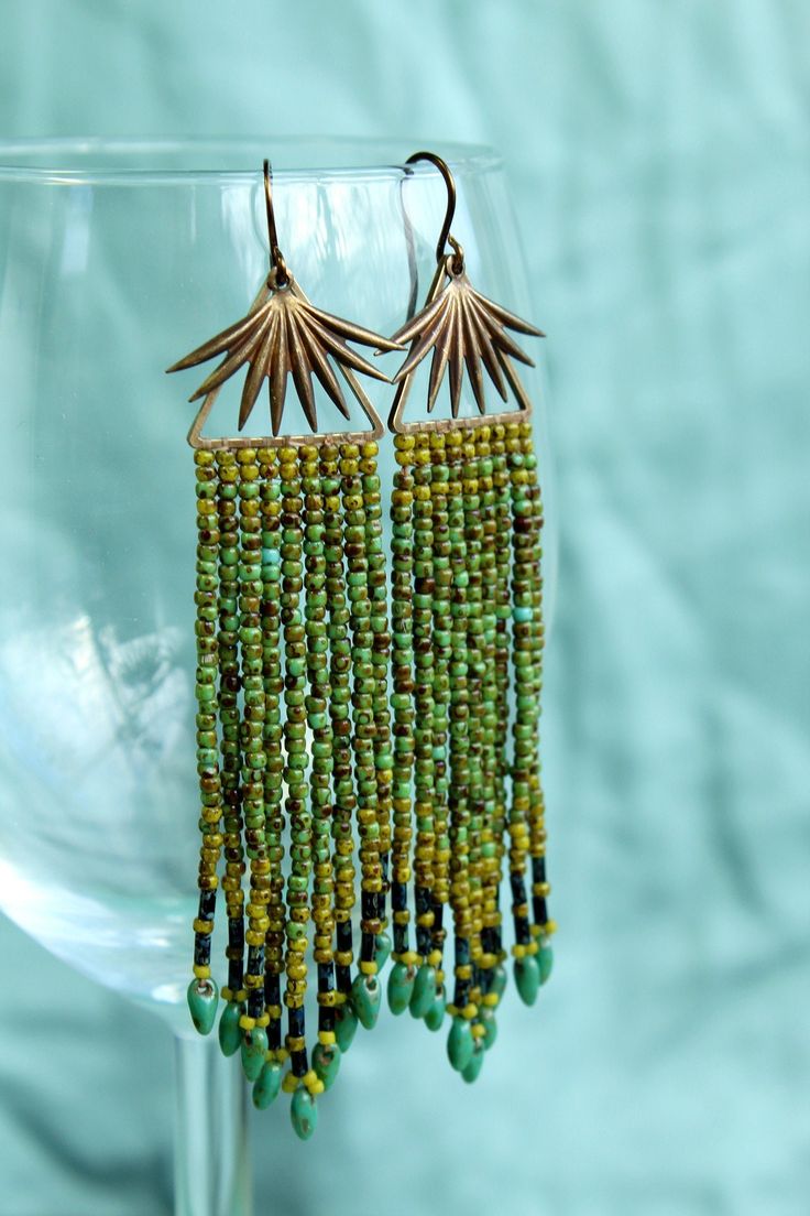 Brass sunburst over fringe. Turquoise and light green seeds beads with picasso finish make the fringe. Turquoise blue mini daggers dangle at the bottom.  Drop length: 3.25 inches - Dimensions of item are shown in photos and/or noted in description. - Lead and nickel free. - For more listings, please visit https://www.etsy.com/shop/WildWaresJewelry - All packaging for Wild Wares products either contains recycled material, reused material and/or is compostable. No new non-biodegradeable plastic is Green Beaded Dangle Earrings With Latkans, Turquoise Beaded Fringe Tassel Earrings For Festival, Turquoise Fringe Beaded Earrings For Festival, Green Bohemian Chandelier Earrings With Tassels, Bohemian Green Fringe Jewelry, Bohemian Turquoise Tassel Earrings With Beaded Fringe, Bohemian Green Beaded Fringe Earrings, Turquoise Beaded Fringe Dangle Tassel Earrings, Turquoise Fringe Beaded Earrings For Beach