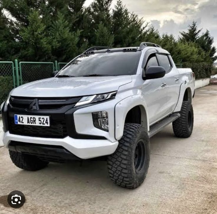 a white truck parked in front of a fence