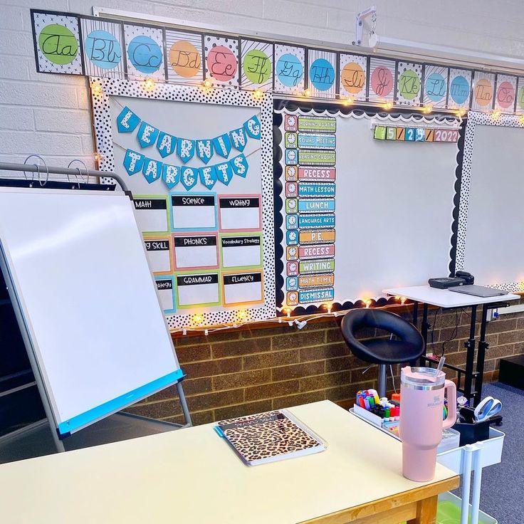 a classroom with desks and whiteboards on the wall next to a chalkboard