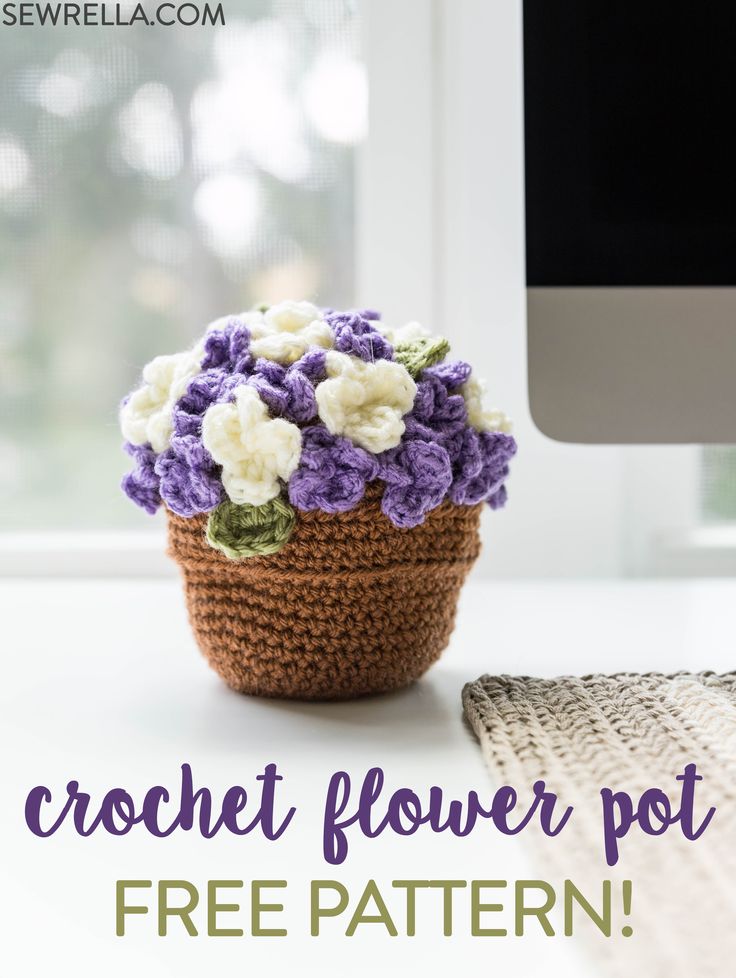 a crocheted flower pot sitting on top of a white table next to a computer