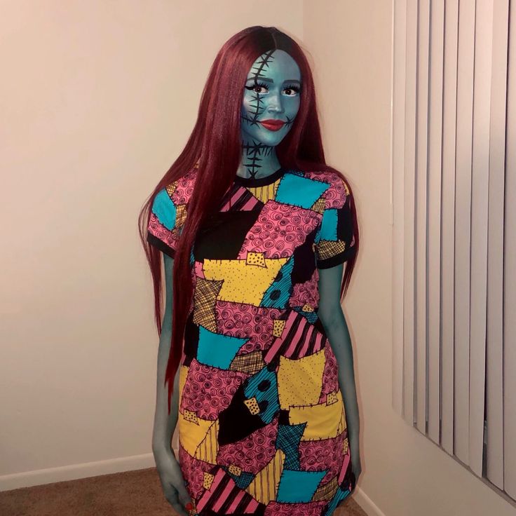 a woman with red hair and makeup is dressed in a colorful dress while standing next to a radiator