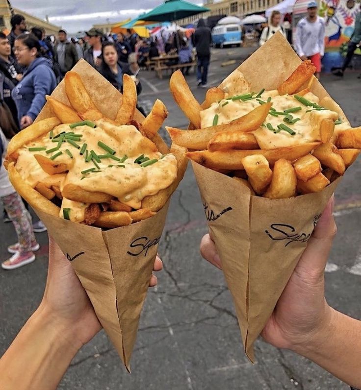 two people holding up some food in their hands