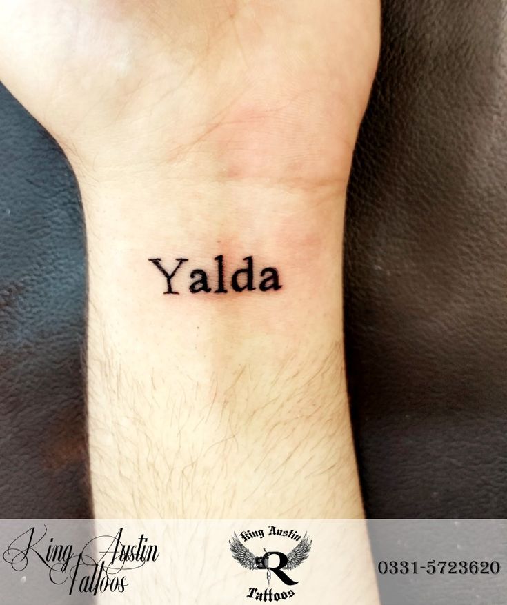 a person with a tattoo on their wrist that says yalda written in black ink