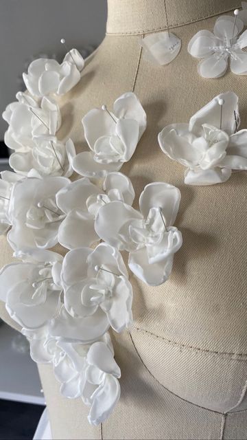 white flowers on a mannequin with buttons in the shape of leaves and petals