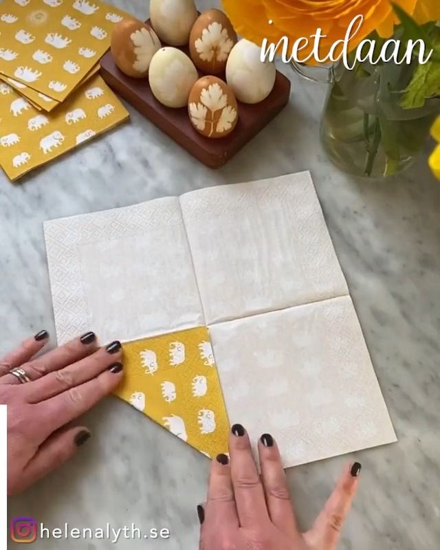 a woman is making an origami quilt with yellow and white squares on it